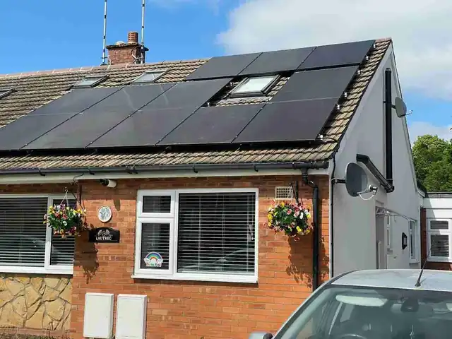 Solar panels on a UK roof with blue sky